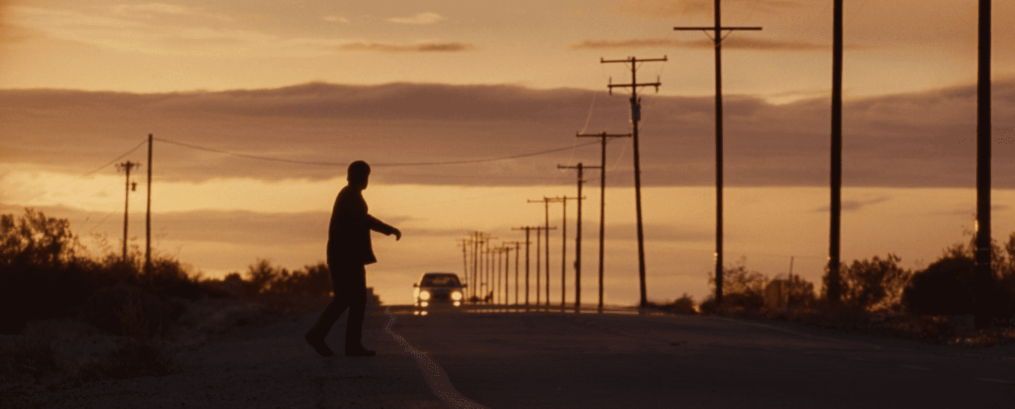 un homme sur le bord de l'autoroute à contre jour