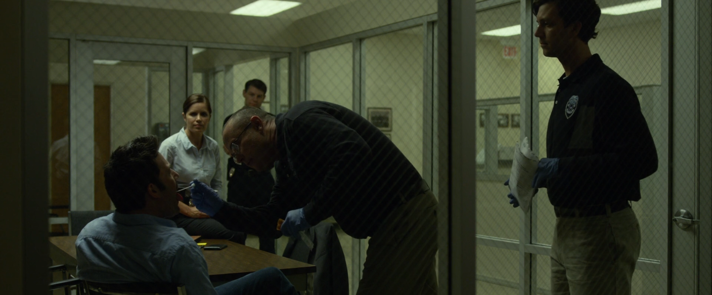 Nick se soumettant à un prélèvement bucal au commissariat