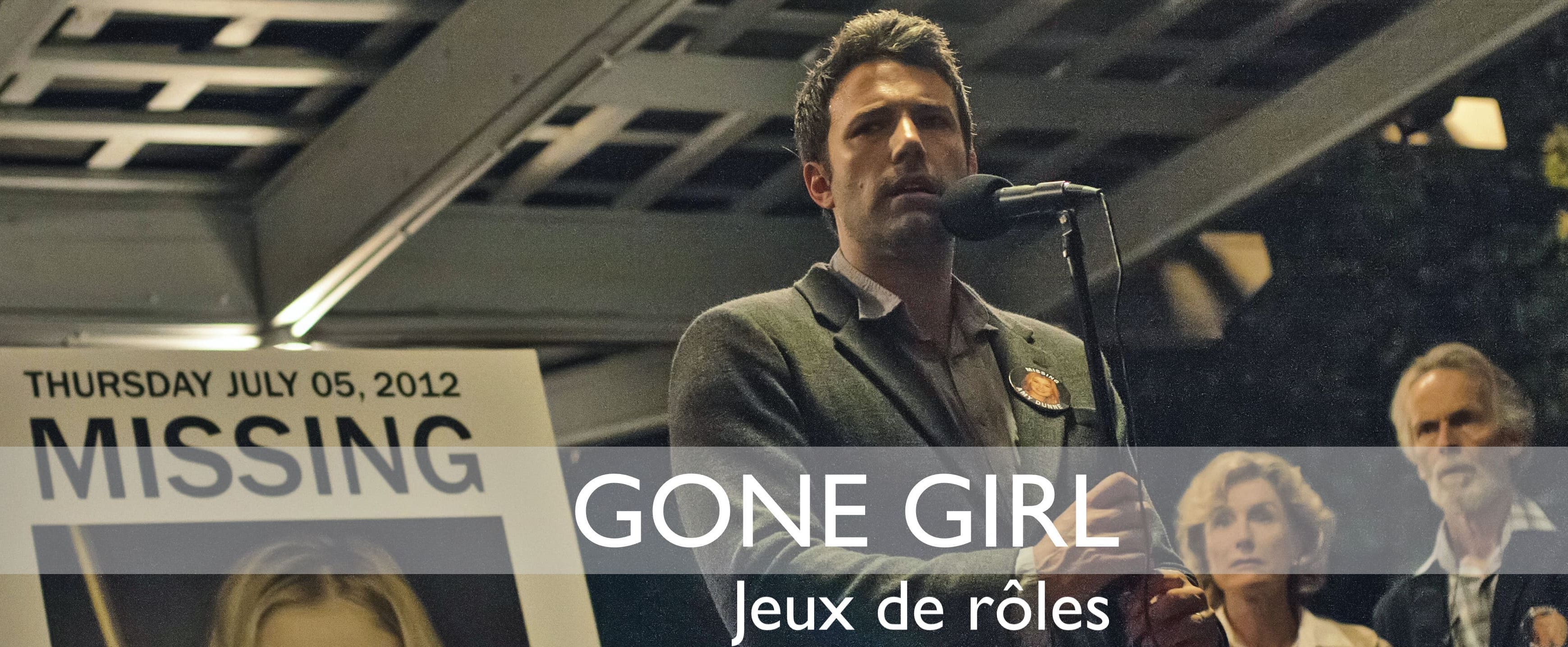 Nick Dunne devant un portrait de sa femme disparue