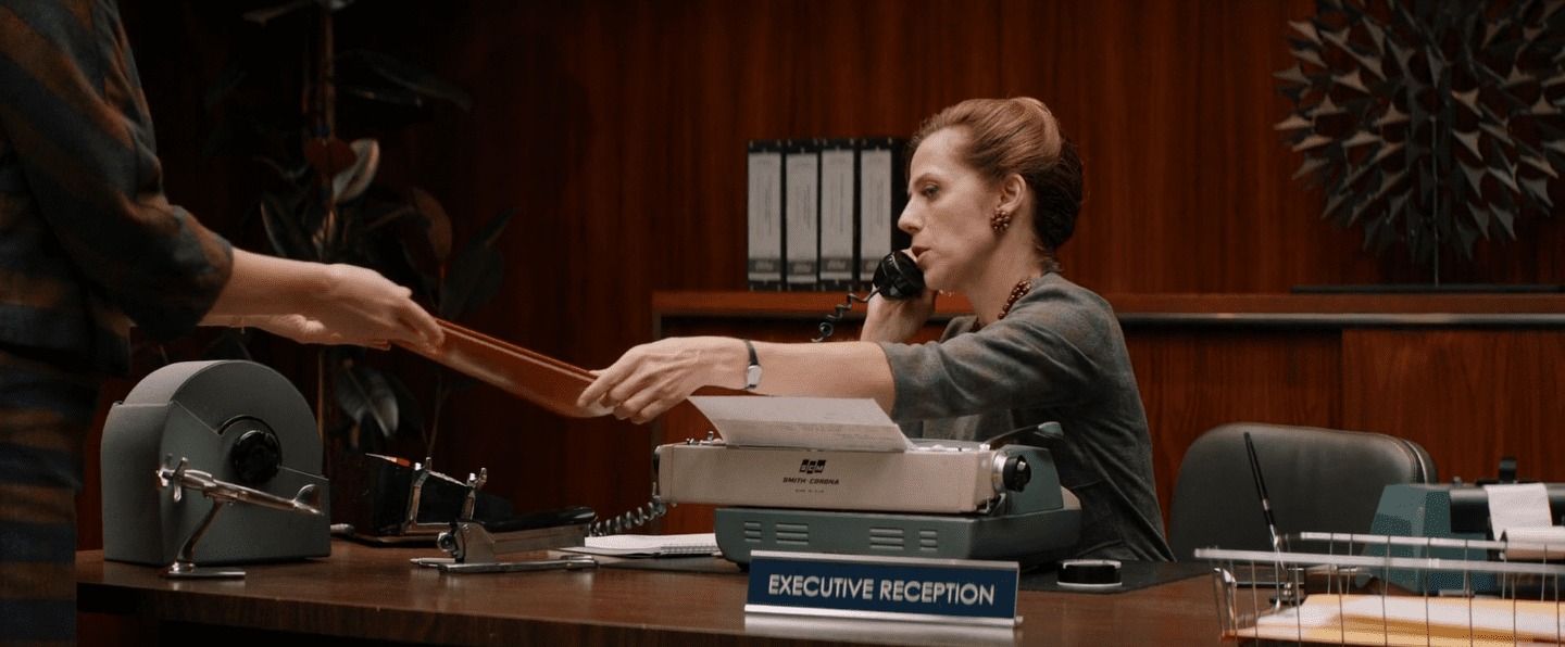 la secrétaire donne le dossier à quelqu'un d'autre