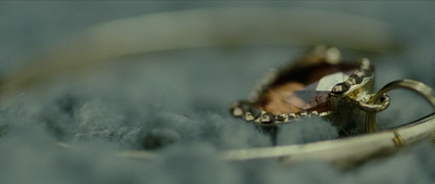 très gros plan sur un bijou et le reflet de Brandon sur celui-ci