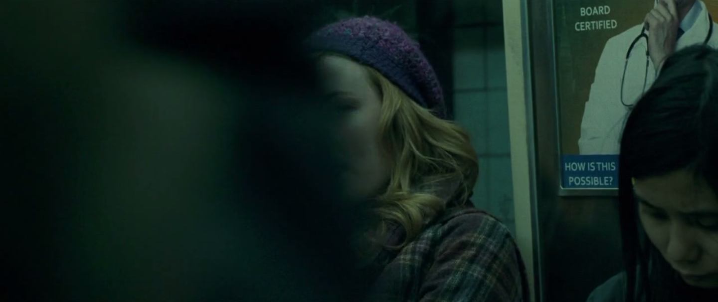 une personne passe devant la femme alors qu'elle se mord les lèvres