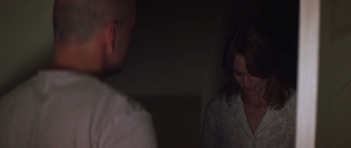 Audrey se tient dans l'embrasure de la porte et parle à David en fondant en larmes