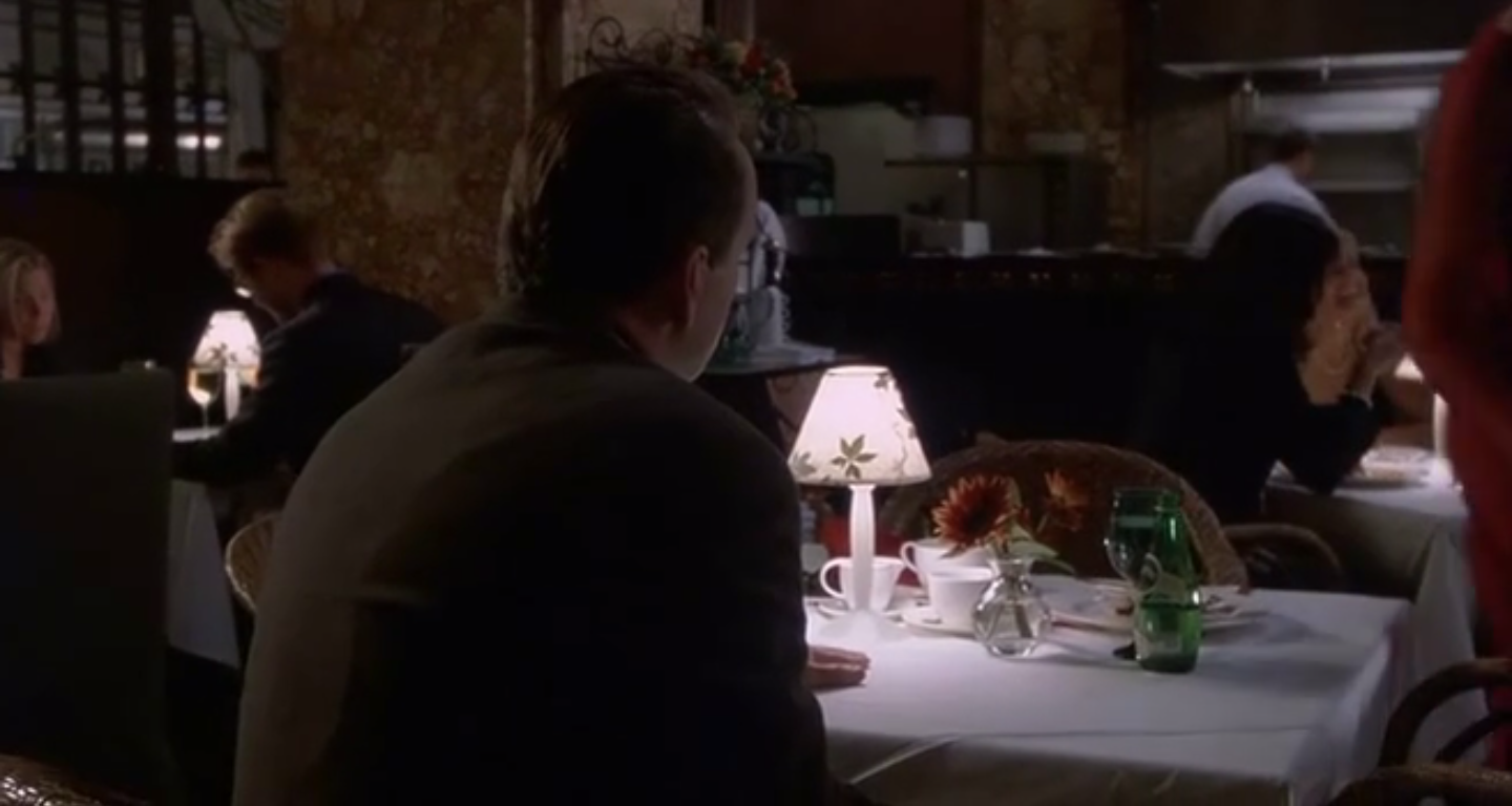 Anna est partie. Malcolm est seul à la table.