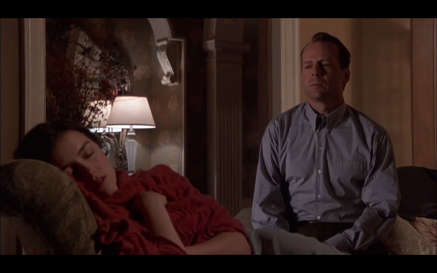 Malcolm vient de s'assoir à la table. Plan large.