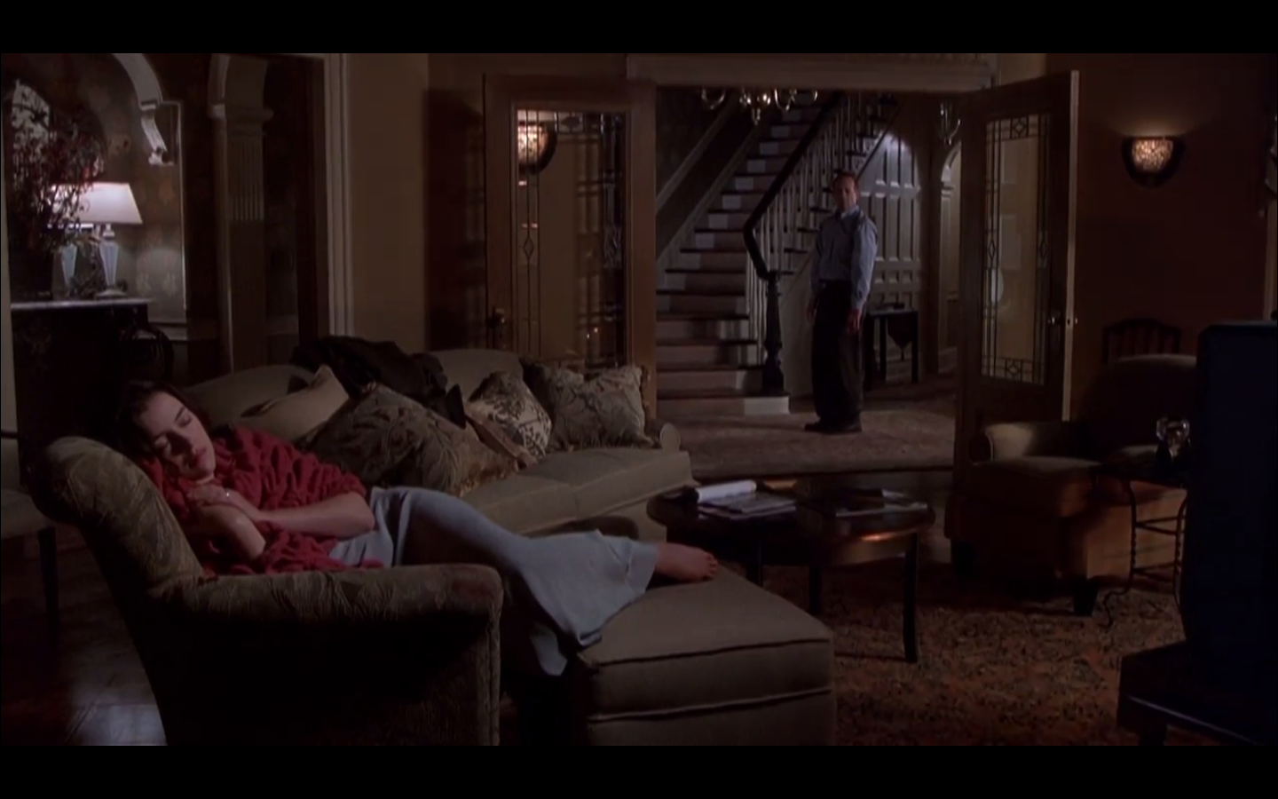 plan large de la pièce avec Malcolm au fond dans l'embrasure de la porte